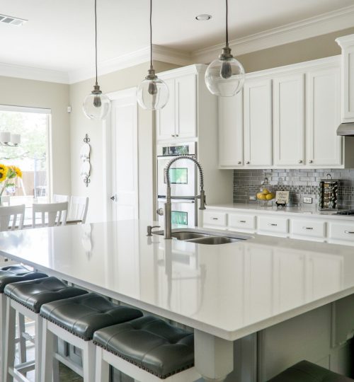 Spacious modern kitchen with white cabinets and island in natural light.