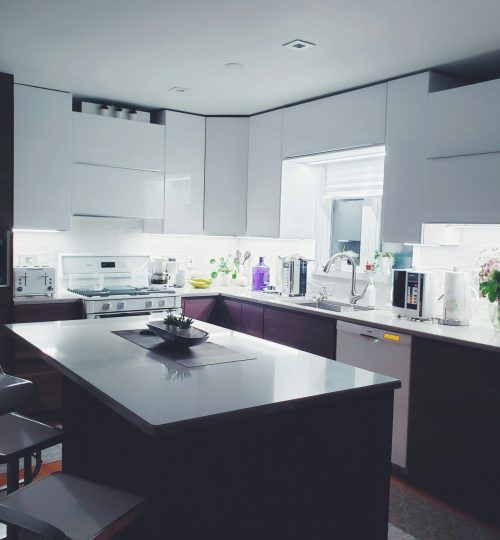 Contemporary kitchen interior with sleek white cabinets and island, perfect for a minimalist aesthetic.