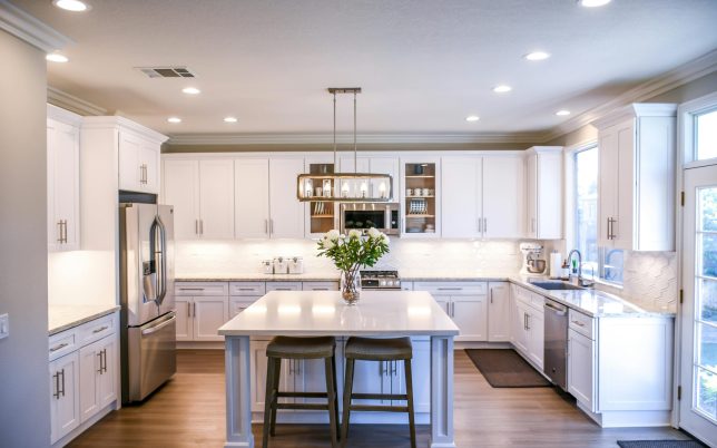 Spacious and elegant kitchen featuring white cabinetry, island, and stainless steel appliances.